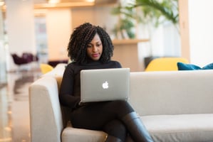 Employee using a laptop sitting on a sofa