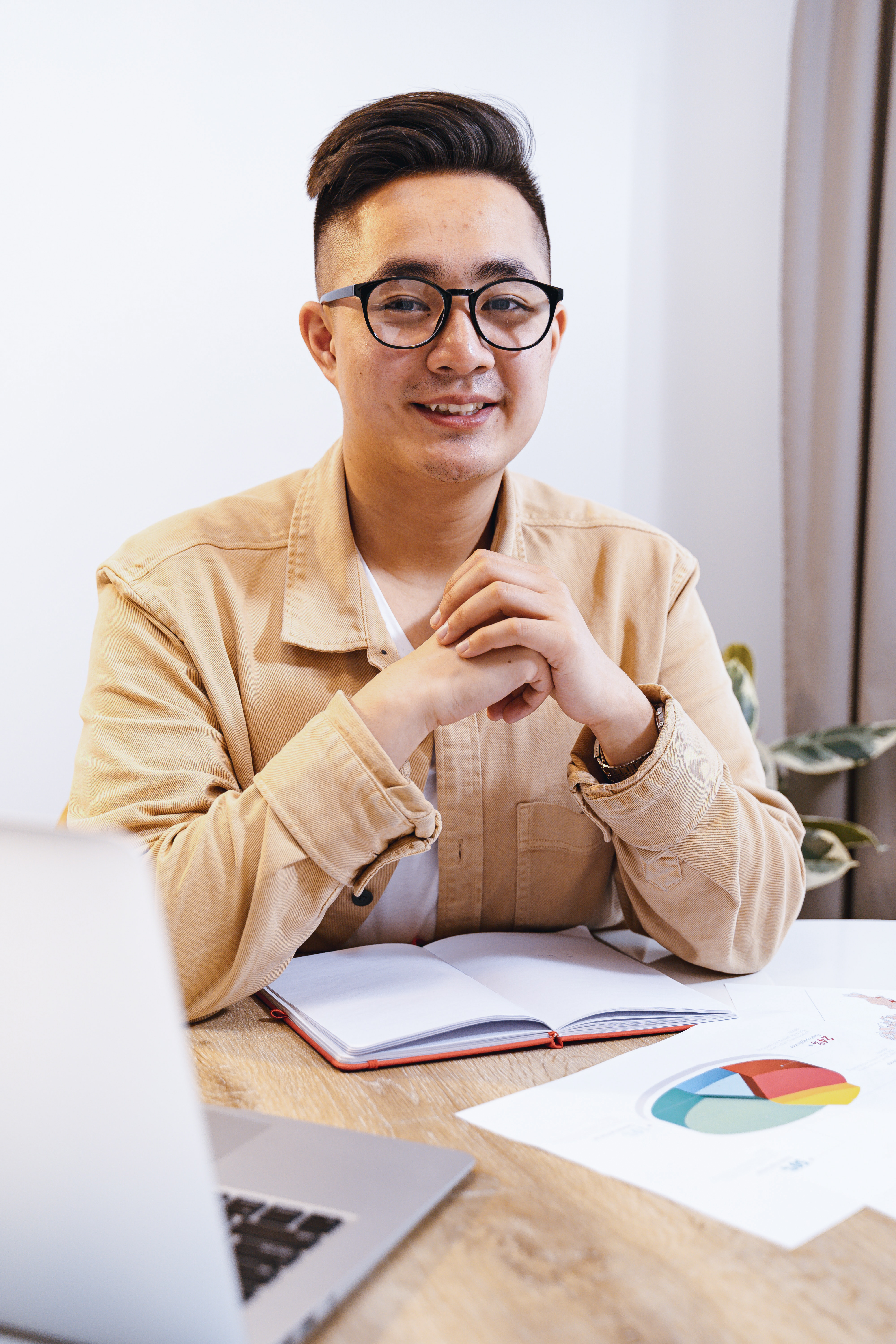 Employee at desk with notepad smiling at the camera